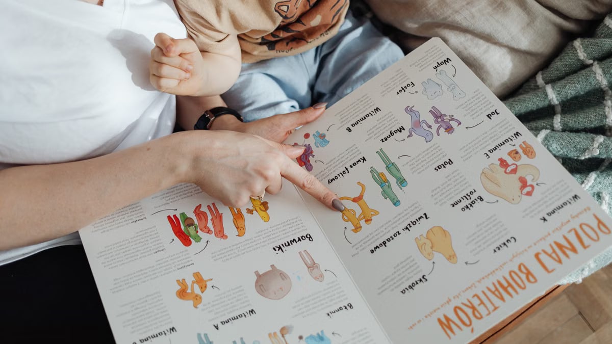 A comforting moment of a mother reading a colorful picture book with her child.